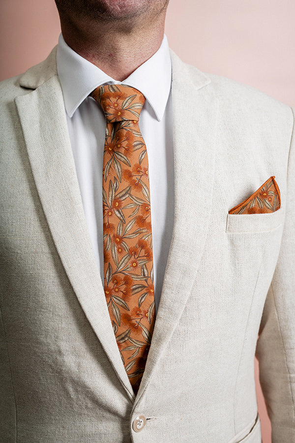 100% cotton tie showcasing the iconic Australian flowering gum in vibrant colors on a terracotta base, ideal for enhancing any outfit