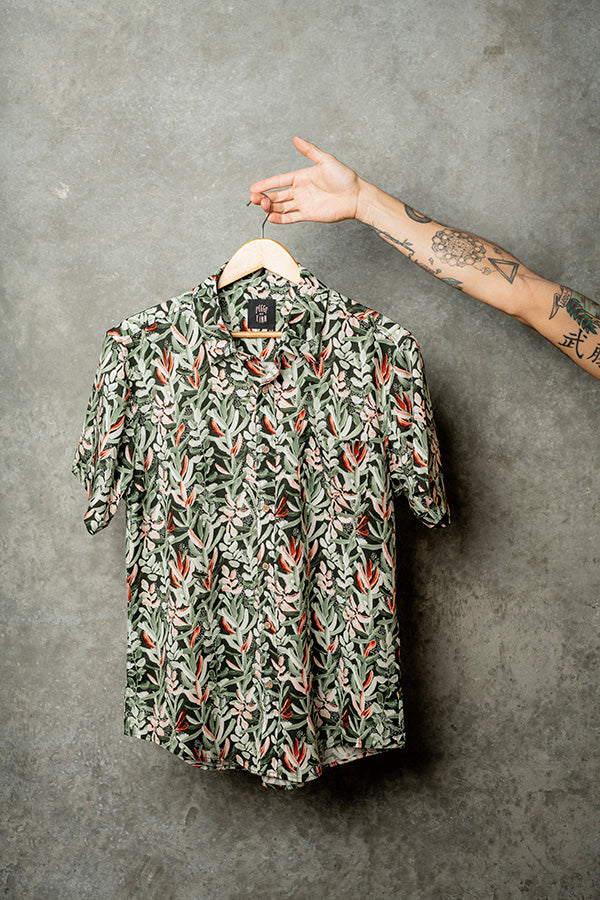 Hanging casual green shirt adorned with vibrant Protea flowers for a stylish look