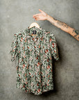 Hanging casual green shirt adorned with vibrant Protea flowers for a stylish look