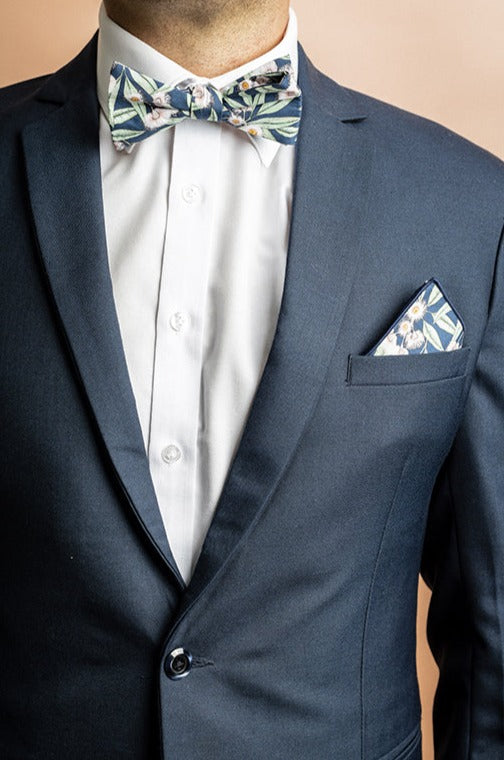 Elegant pocket square featuring a detailed print of pale pink flowering gum blossoms on a steel blue background, perfect for adding a touch of natural beauty to formal attire