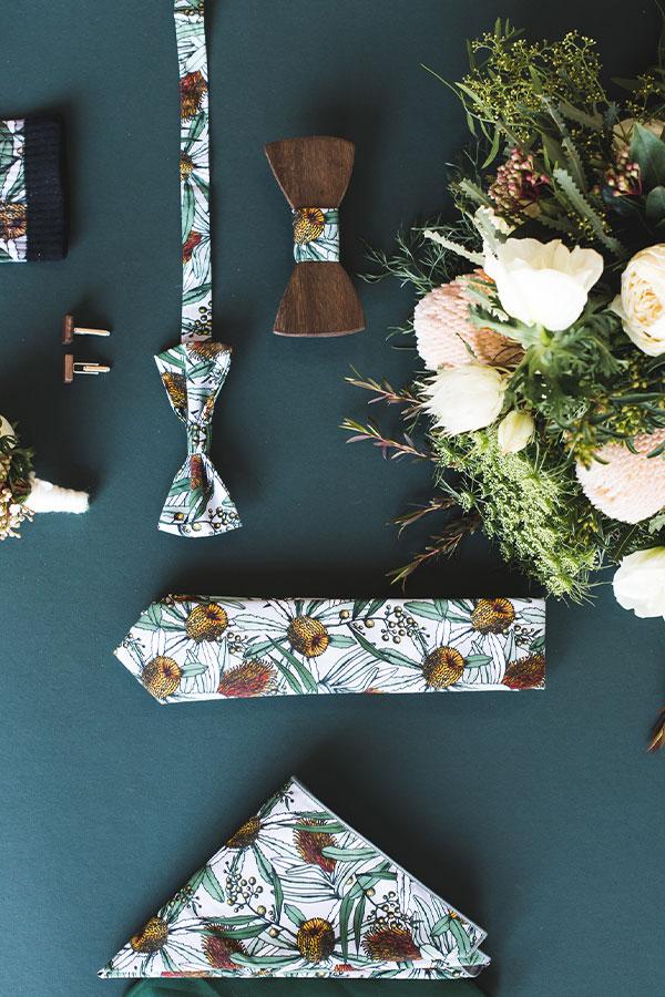 Men's fashion accessories featuring native Banksia flora against a classic grey background, including ties, socks, and pocket squares, perfect for weddings and formal events
