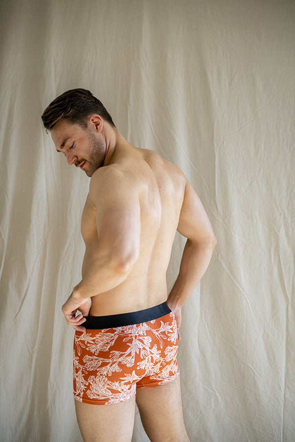 Eco-friendly, comfortable men's underwear in burnt orange with distinctive white floral outlines