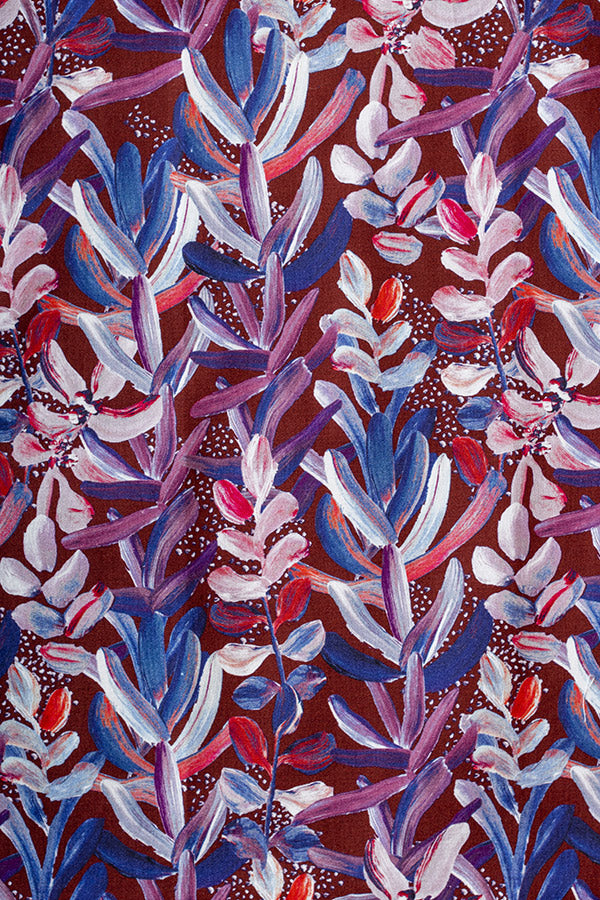 Rich burgundy background featuring white painted protea flowers, highlighting the unique and elegant floral design